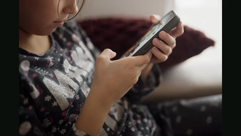 Watching on a smartphone while sitting on a couch at home